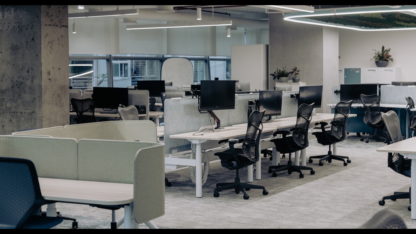 Boş bir açık ofis alanı, sıralı çalışma masaları ve sandalyeler